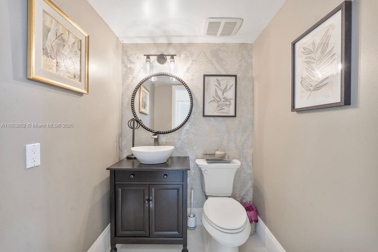 13000 Old Cutler Road Pinecrest, FL 33156 - Photo 10 of 43 a bathroom with a toilet a sink and a mirror