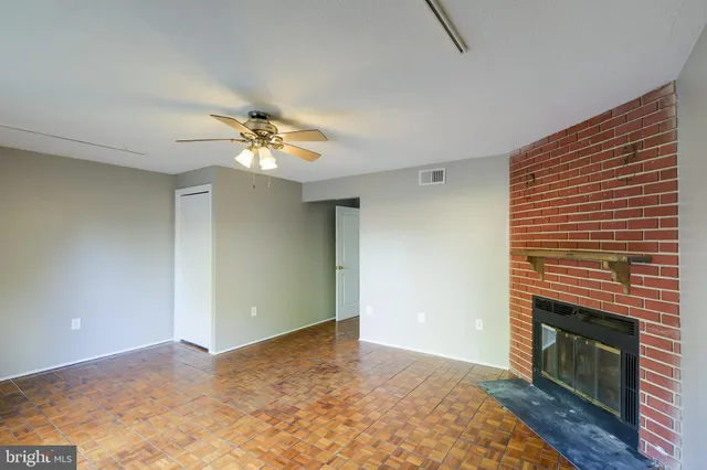 a view of an empty room with a chandelier fan