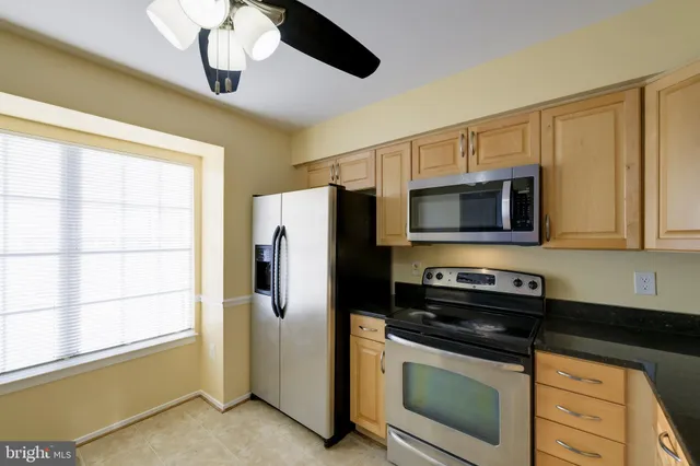 a kitchen with stainless steel appliances a stove microwave and refrigerator
