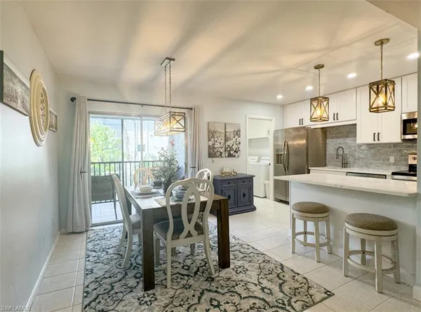 a kitchen with sink refrigerator dining table and chairs