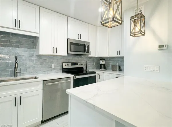 a kitchen with cabinets stainless steel appliances and a sink