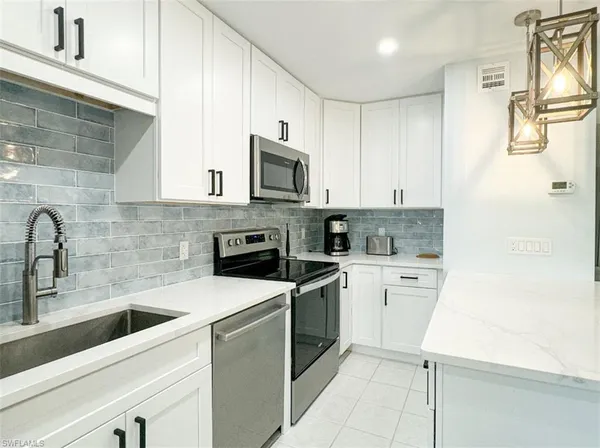 a kitchen with cabinets stainless steel appliances and a sink