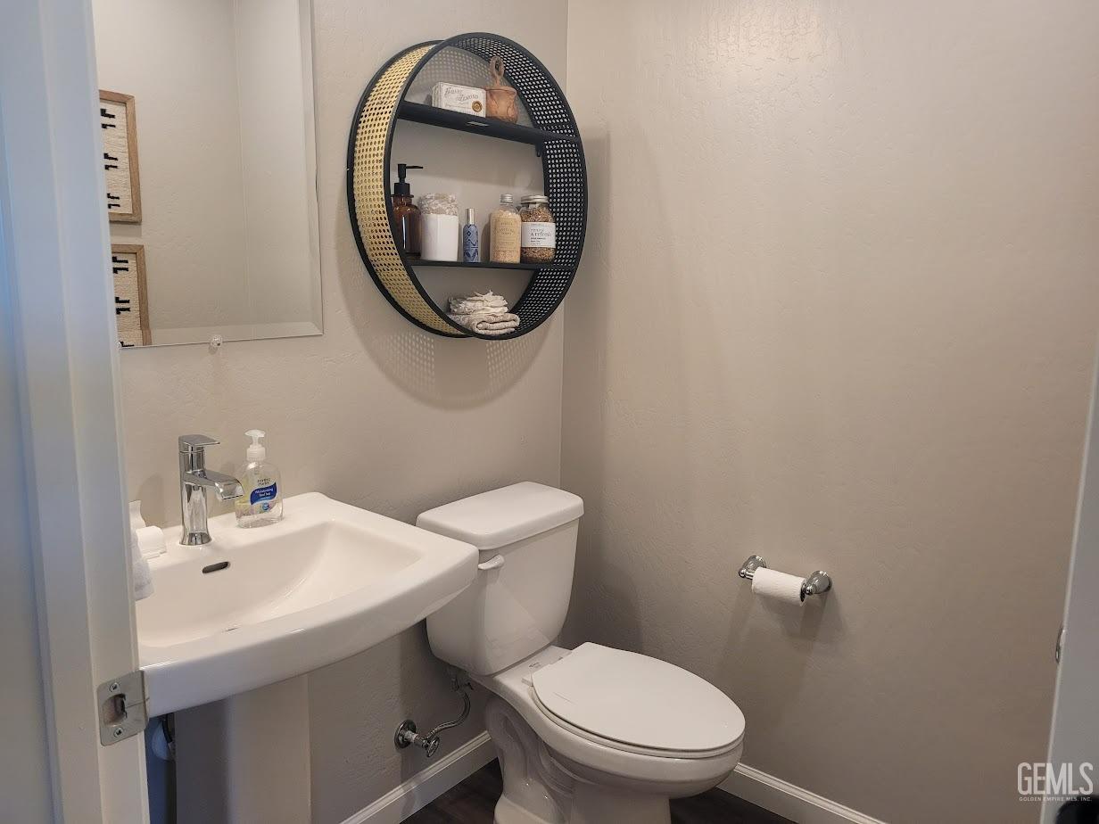 Undisclosed Address Bakersfield, CA 93313 - Photo 9 of 25 a bathroom with a toilet a sink and a mirror