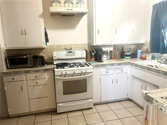 a kitchen with a stove sink and cabinets