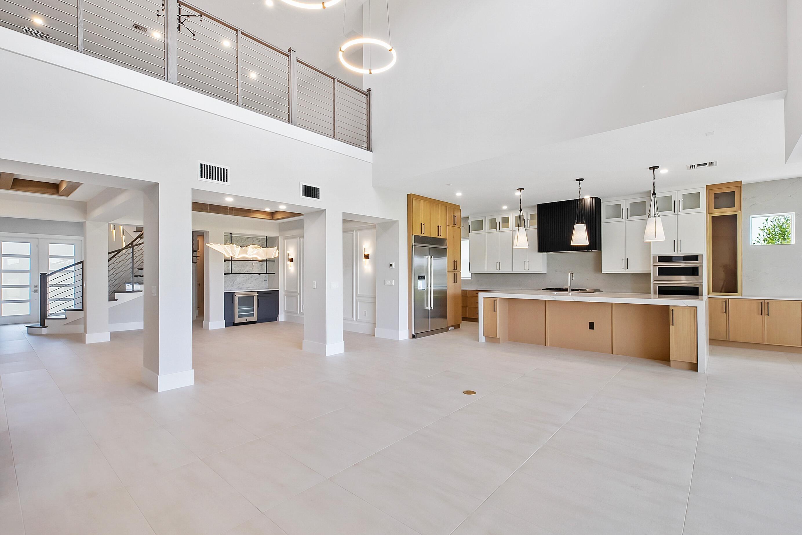 20060 Southeast Bridgewater Drive Jupiter, FL 33458 - Photo 19 of 68 a large white kitchen with stainless steel appliances kitchen island granite countertop a stove a sink a refrigerator and white cabinets with wooden floor