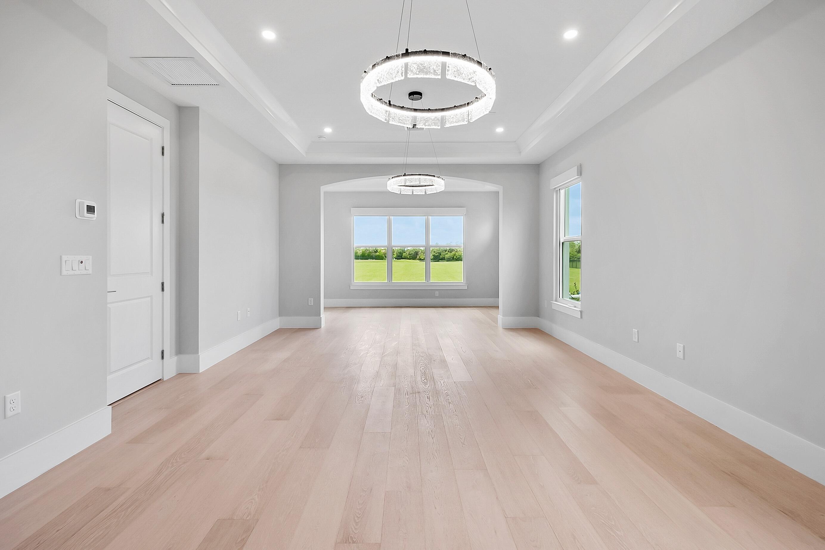 20060 Southeast Bridgewater Drive Jupiter, FL 33458 - Photo 25 of 68 an empty room with windows and chandelier