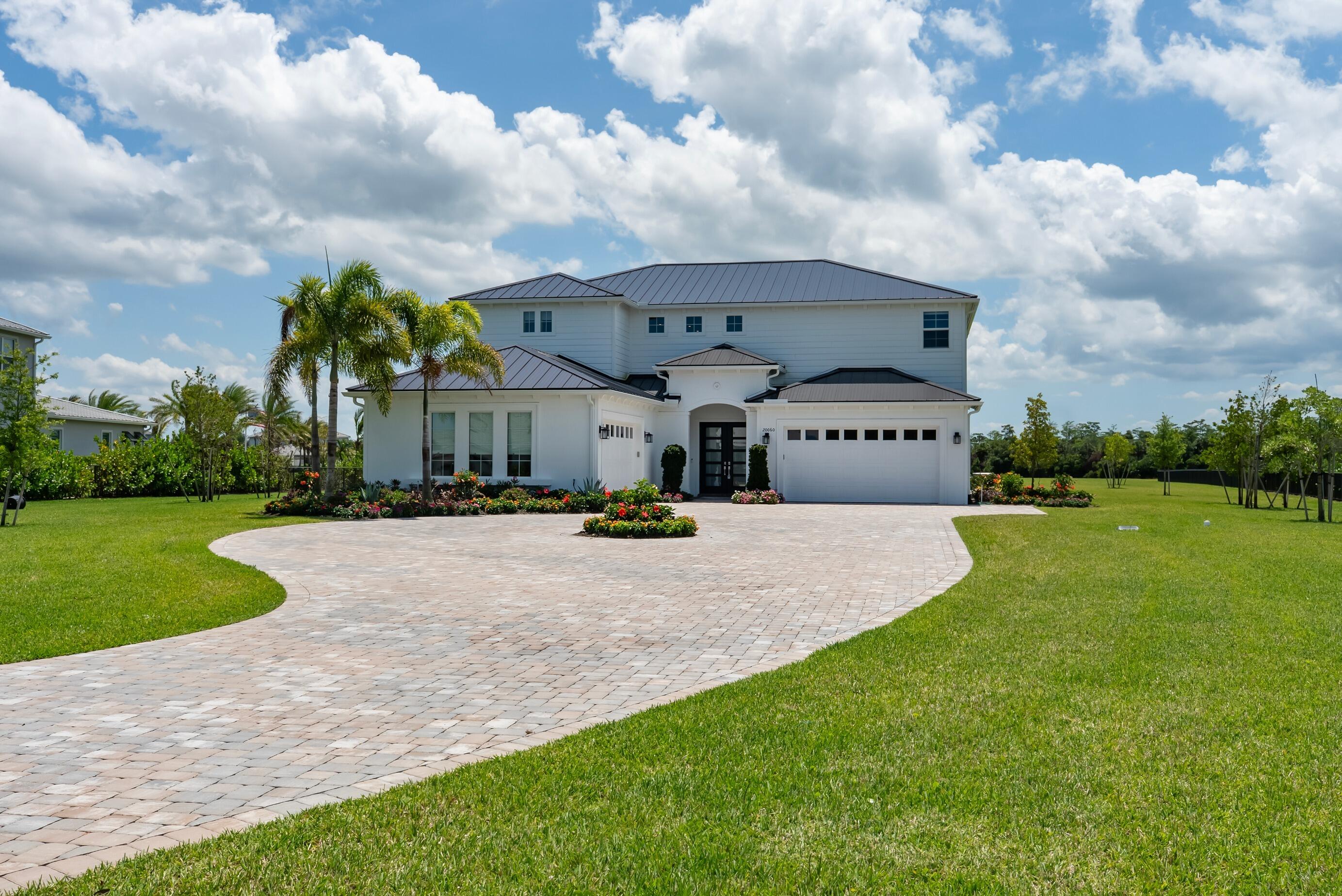 20060 Southeast Bridgewater Drive Jupiter, FL 33458 - Photo 3 of 68 a view of a big house with a big yard potted plants and large tree