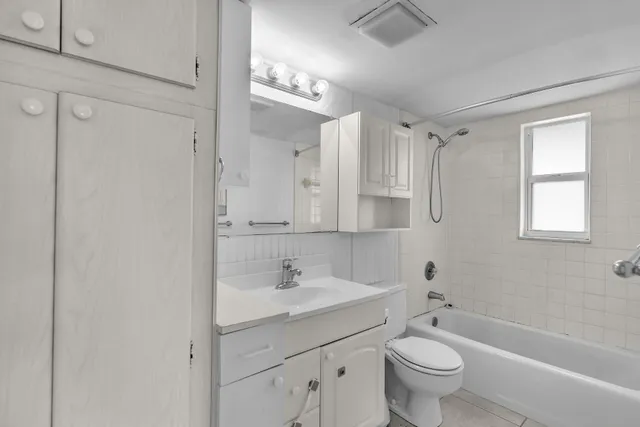 a bathroom with a double vanity sink mirror toilet and bathtub