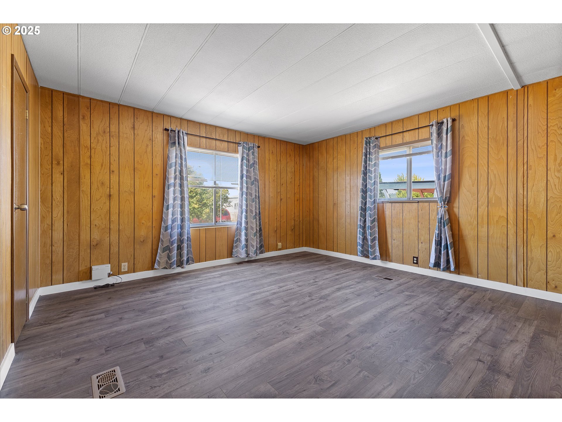 2902 East 2nd Street, Unit 110 Newberg, OR 97132 - Photo 11 of 29 a view of an empty room with window and hardwood floor