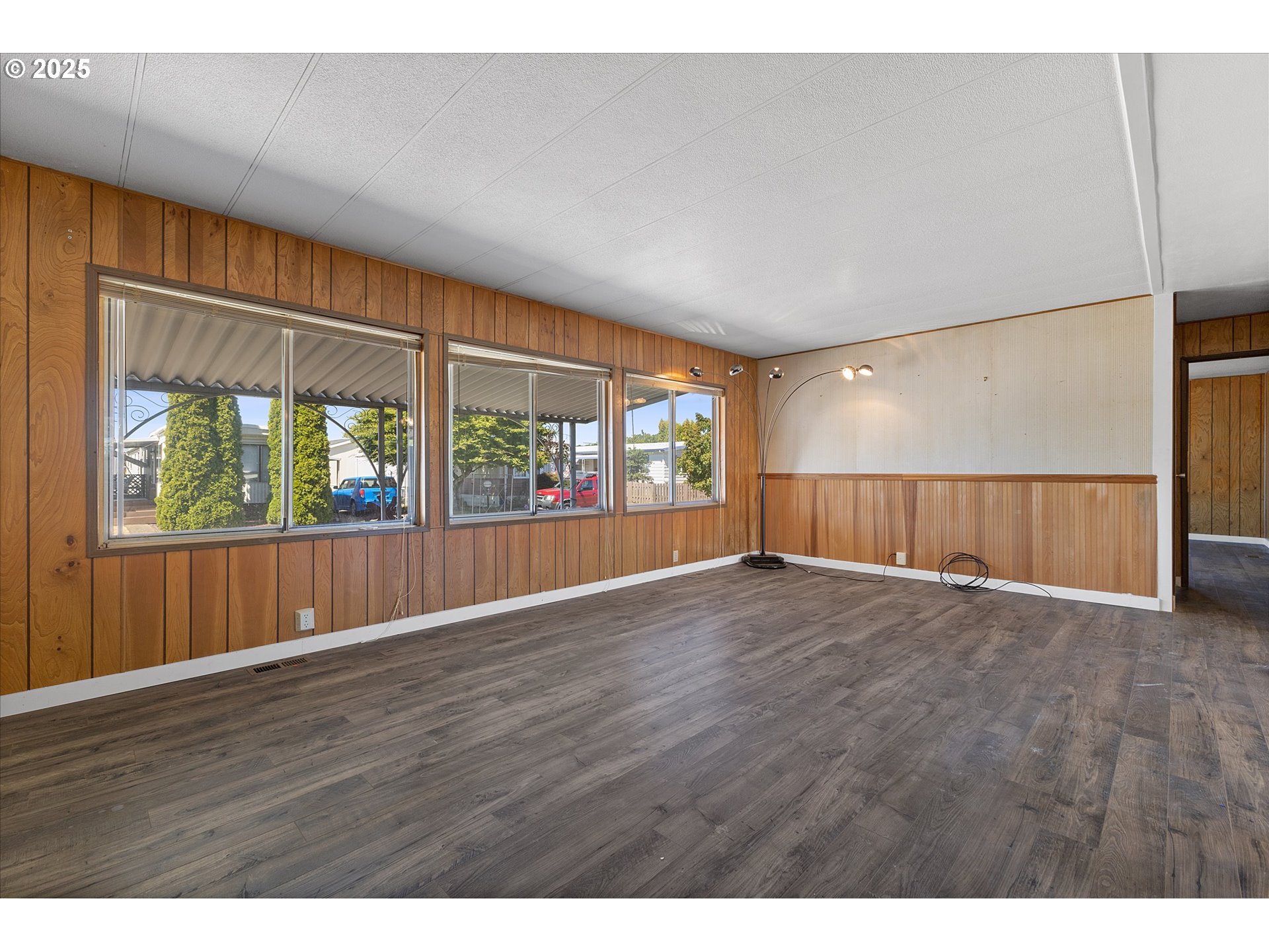 2902 East 2nd Street, Unit 110 Newberg, OR 97132 - Photo 6 of 29 a view of an empty room with wooden floor and a window