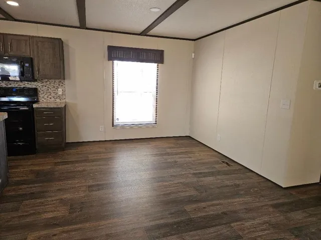a view of a kitchen with wooden floor and a window