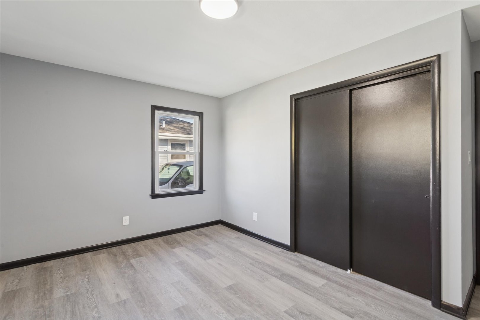 17641 Burnham Avenue Lansing, IL 60438 - Photo 10 of 26 a view of an empty room with wooden floor and a window
