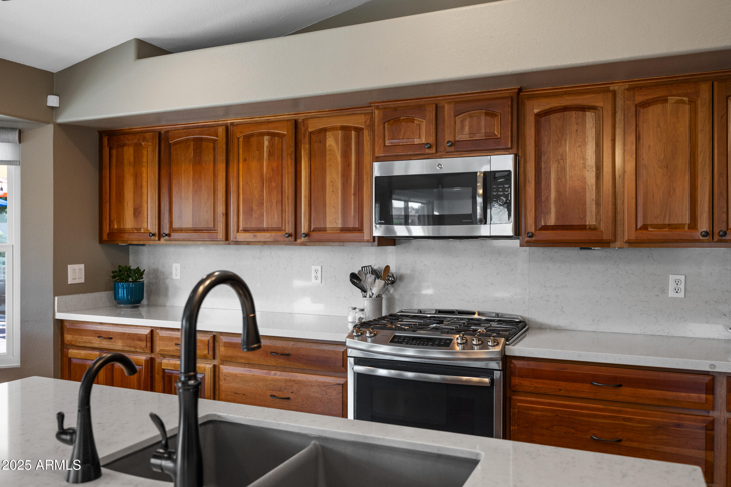 1111 West Lisa Lane Tempe, AZ 85284 - Photo 17 of 58 a kitchen with stainless steel appliances granite countertop a stove and a microwave