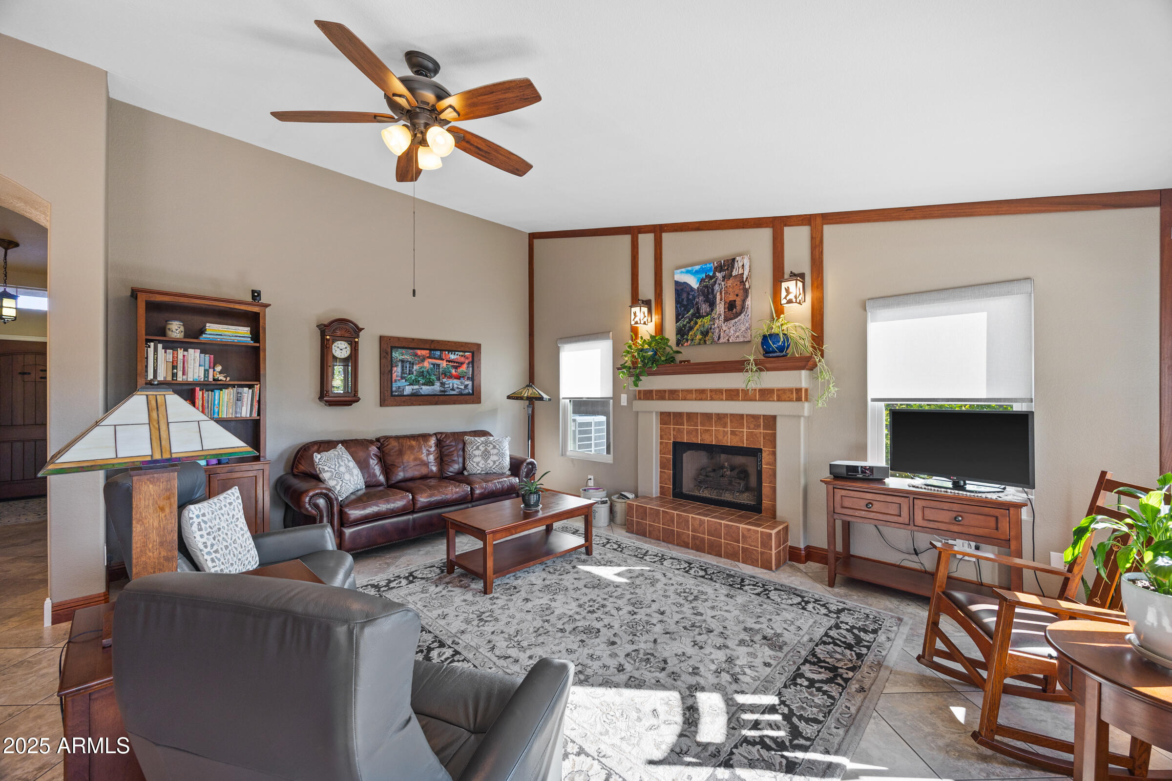 1111 West Lisa Lane Tempe, AZ 85284 - Photo 21 of 58 a living room with furniture a fireplace and a flat screen tv