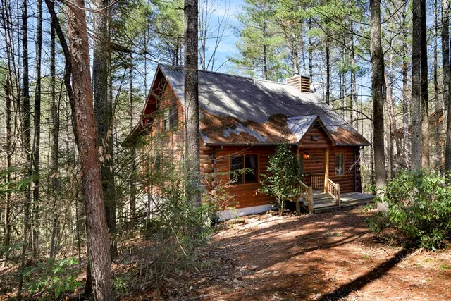a view of a barn with large trees plants and large trees