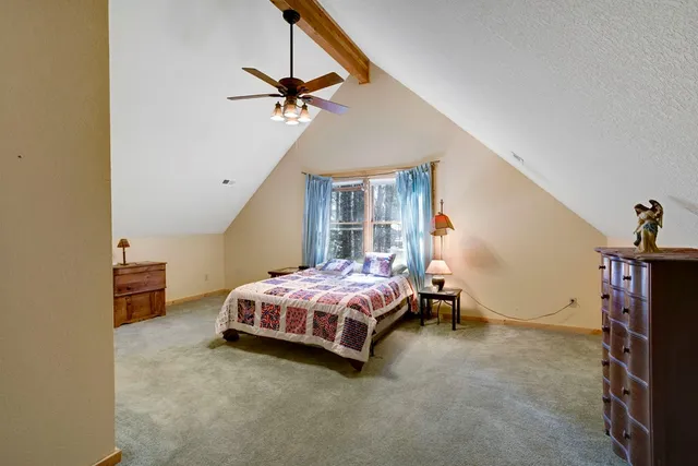 a spacious bedroom with a bed and a chandelier