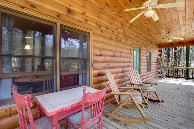 a view of a patio with table and chairs with wooden floor and fence
