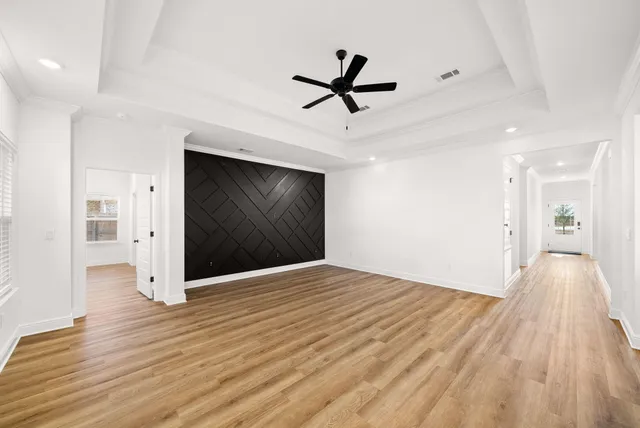 a view of an empty room with wooden floor and a fireplace