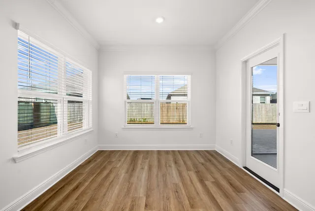 a view of empty room with wooden floor and windows
