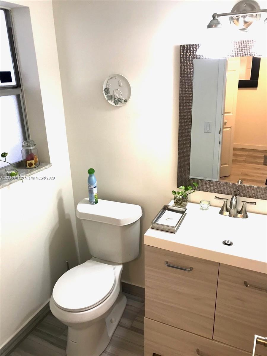 8330 Sands Point Boulevard, Unit N306 Tamarac, FL 33321 - Photo 14 of 20 a bathroom with a toilet sink and mirror