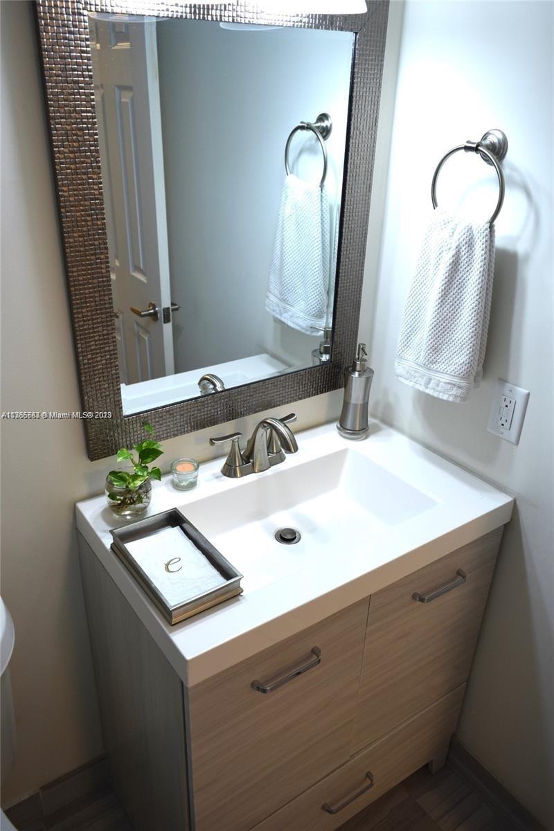 8330 Sands Point Boulevard, Unit N306 Tamarac, FL 33321 - Photo 15 of 20 a bathroom with a sink and a mirror
