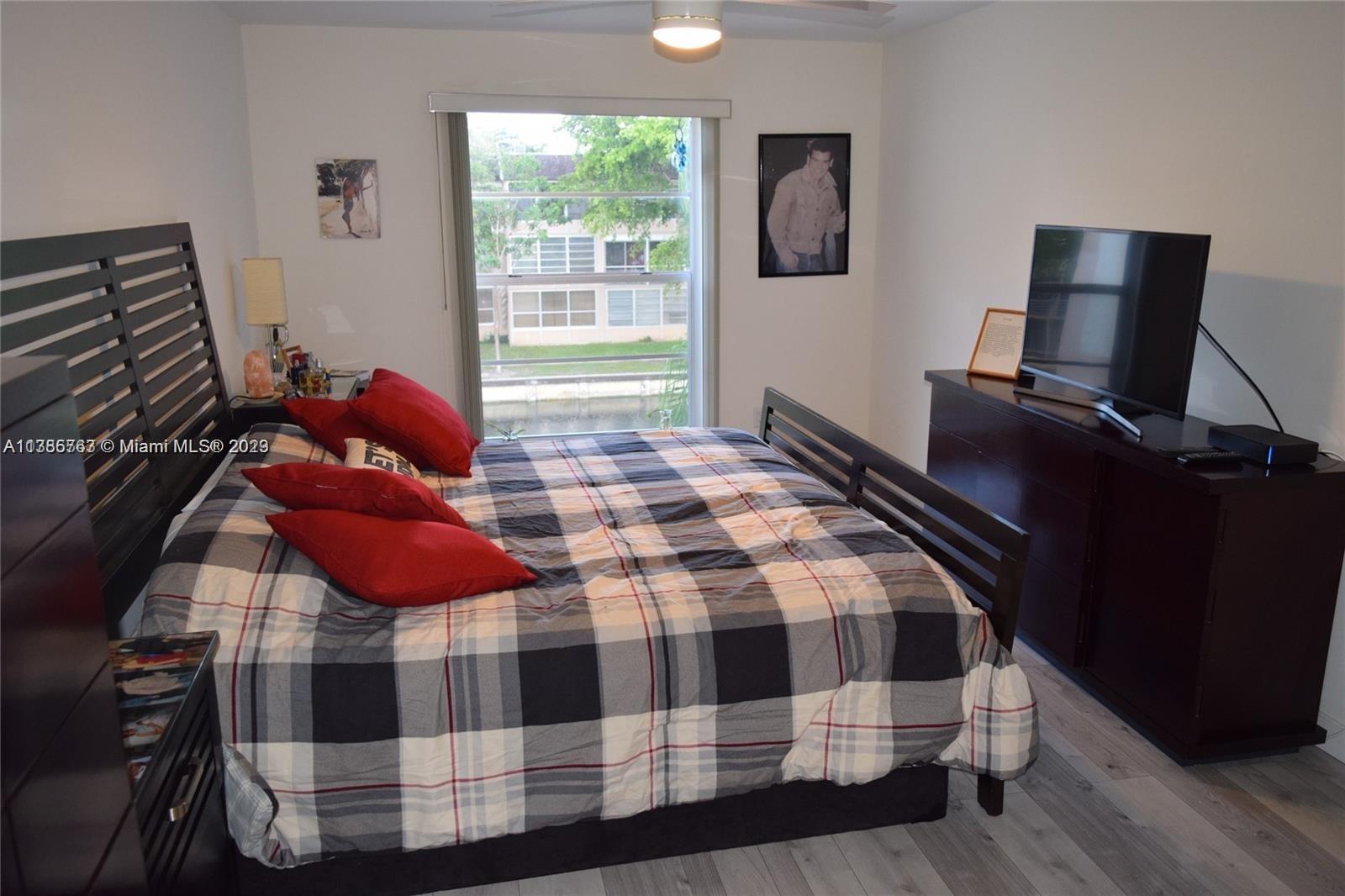 8330 Sands Point Boulevard, Unit N306 Tamarac, FL 33321 - Photo 16 of 20 a bedroom with a bed and wooden floor