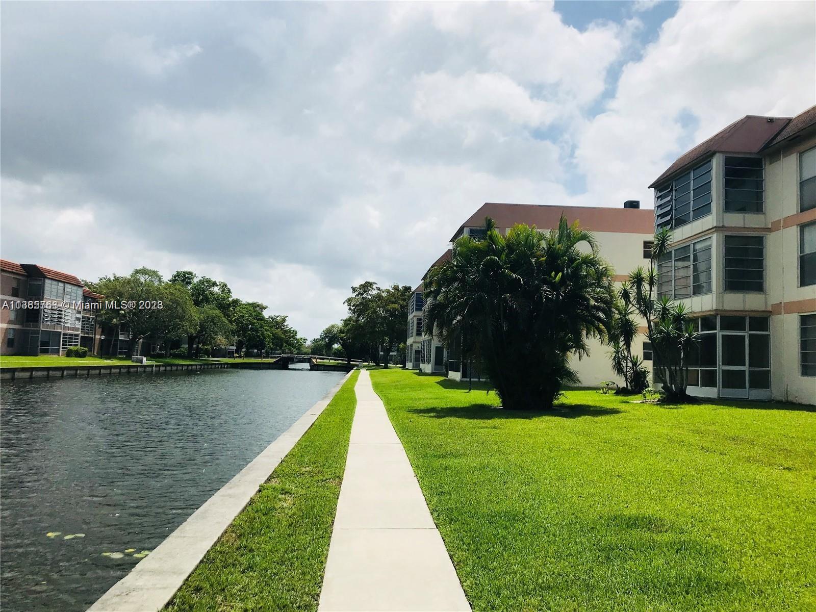 8330 Sands Point Boulevard, Unit N306 Tamarac, FL 33321 - Photo 4 of 20 a view of a lake with a yard in front of it