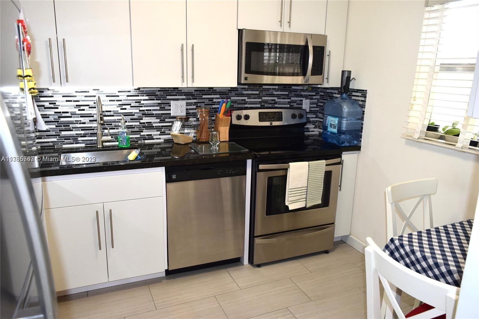 8330 Sands Point Boulevard, Unit N306 Tamarac, FL 33321 - Photo 6 of 20 a kitchen with stainless steel appliances and cabinets