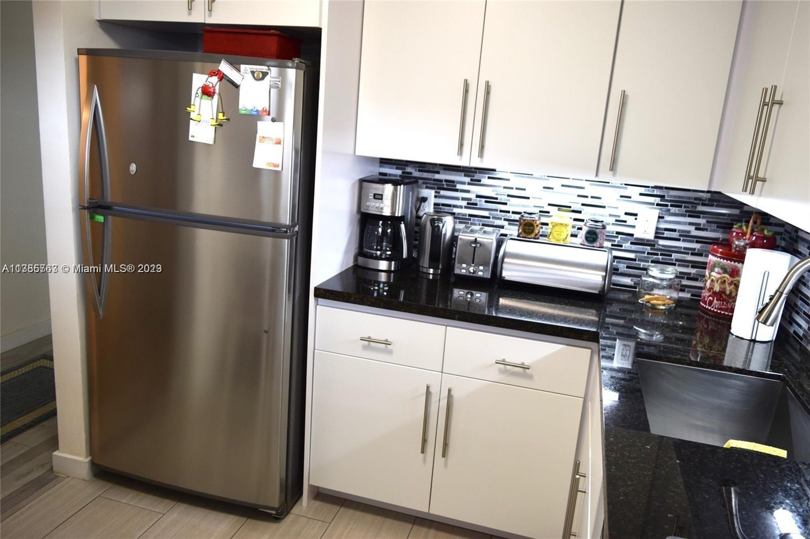 8330 Sands Point Boulevard, Unit N306 Tamarac, FL 33321 - Photo 8 of 20 a kitchen with appliances and cabinets
