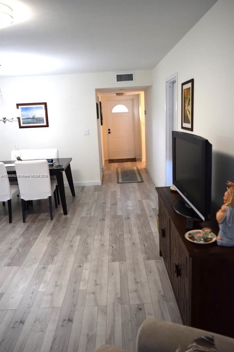 8330 Sands Point Boulevard, Unit N306 Tamarac, FL 33321 - Photo 9 of 20 a living room with furniture and a flat screen tv