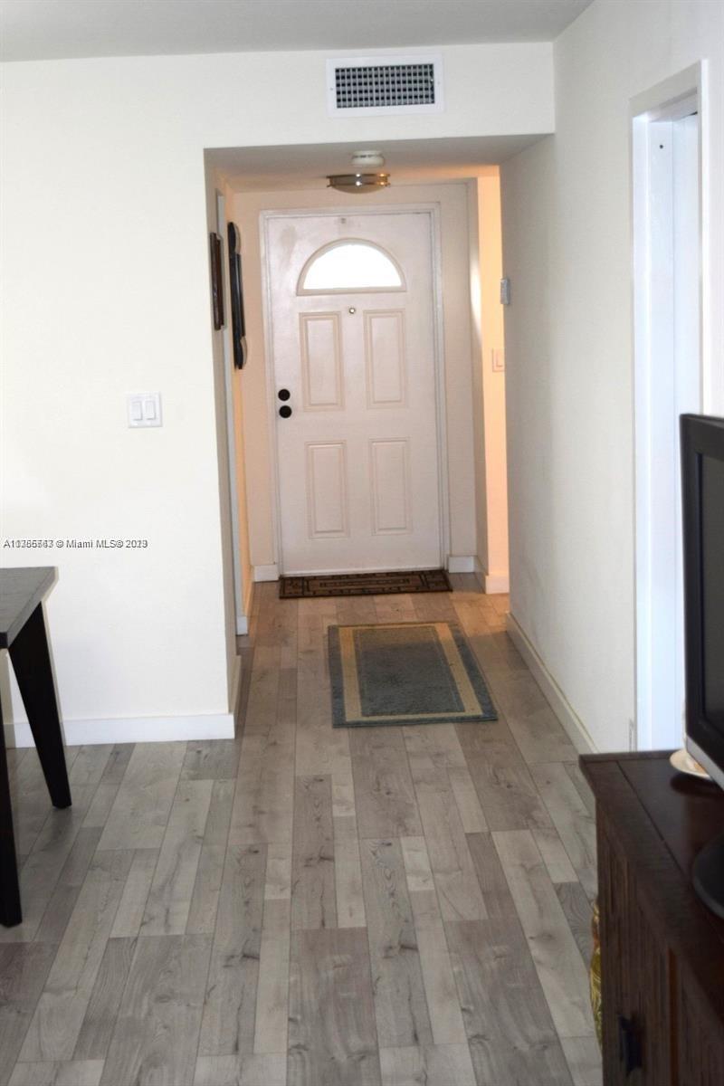 8330 Sands Point Boulevard, Unit N306 Tamarac, FL 33321 - Photo 10 of 20 a view of a hallway with wooden floor and a living room
