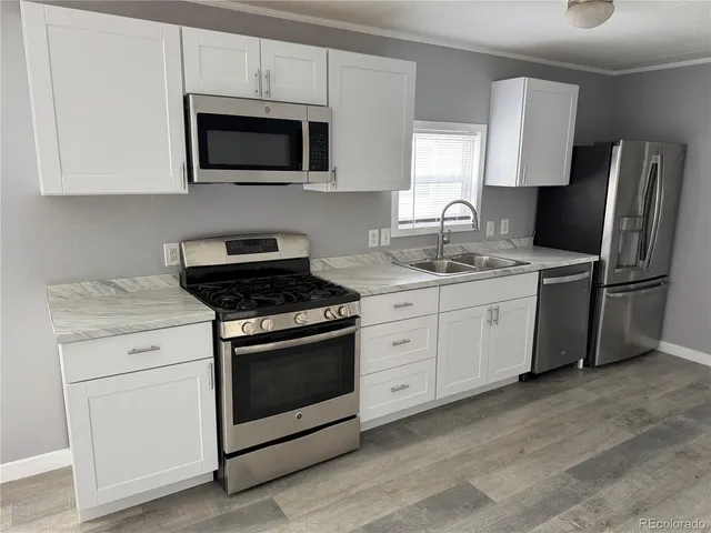 a kitchen with stainless steel appliances granite countertop a stove a microwave a sink and cabinets