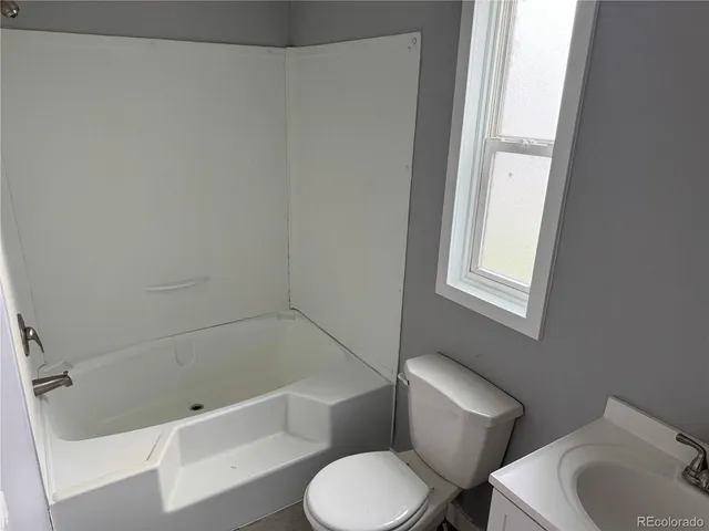 a bathroom with a toilet and a tub