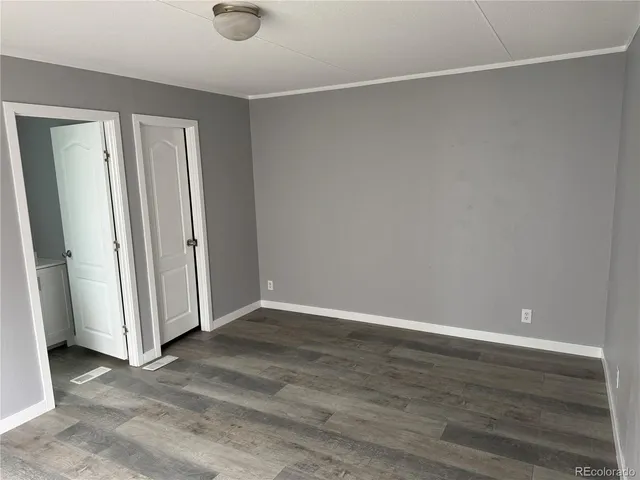 an empty room with wooden floor and window