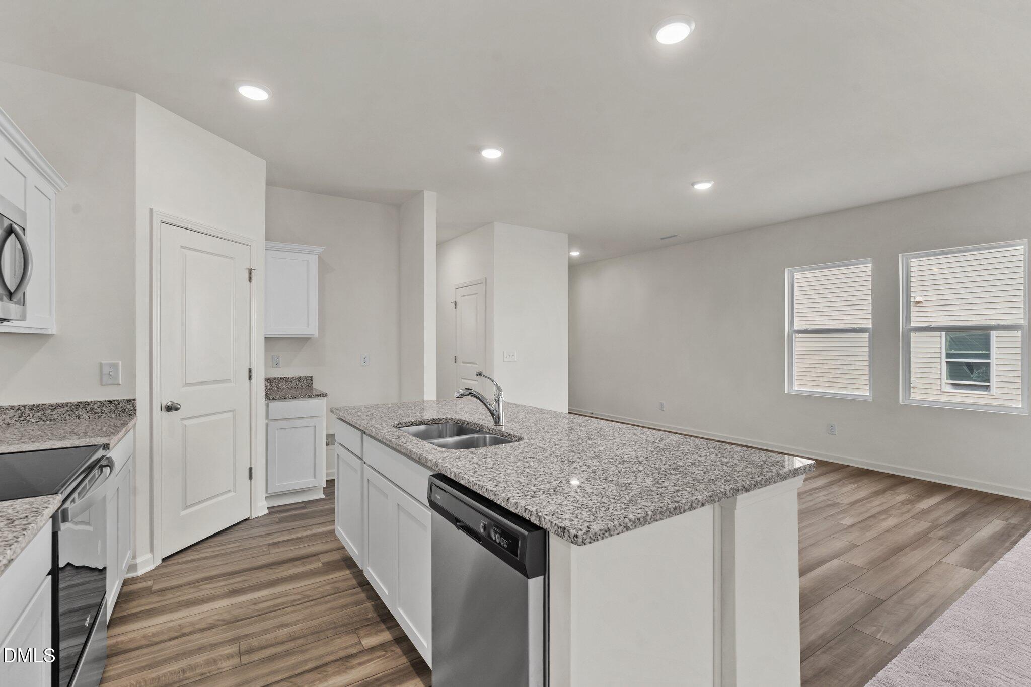 305 Cherubic Way Rolesville, NC 27571 - Photo 12 of 29 a kitchen with stainless steel appliances granite countertop a sink stove and cabinets