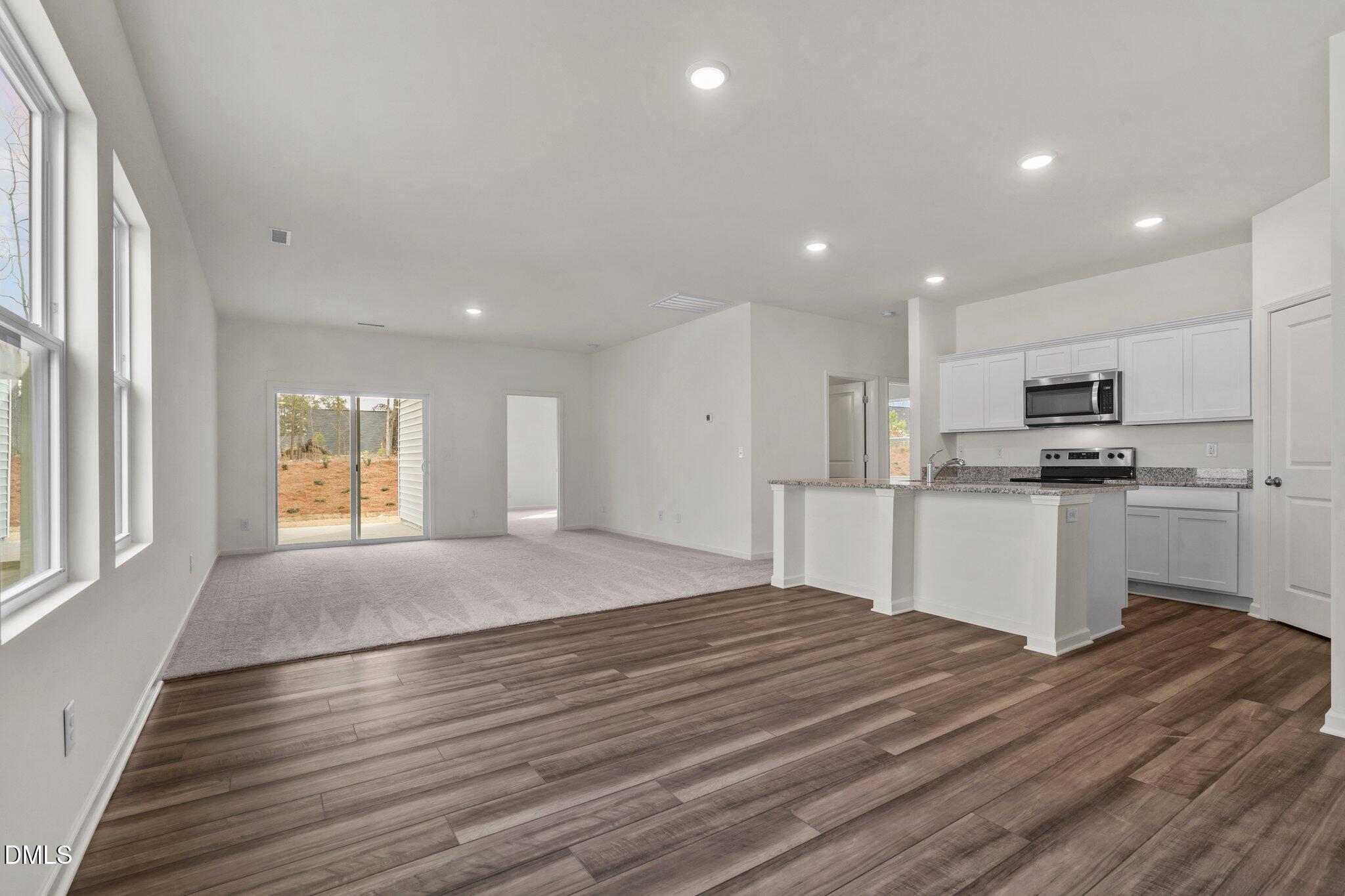305 Cherubic Way Rolesville, NC 27571 - Photo 8 of 29 a kitchen with stainless steel appliances granite countertop a stove a sink and a refrigerator