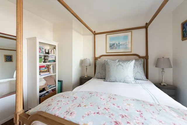 a bedroom with a bed and painting on the wall