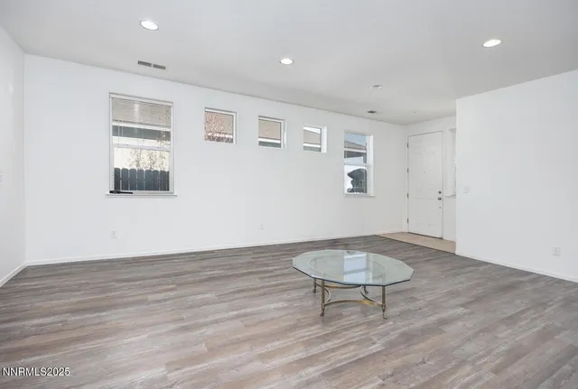 a view of a room with wooden floor and a table
