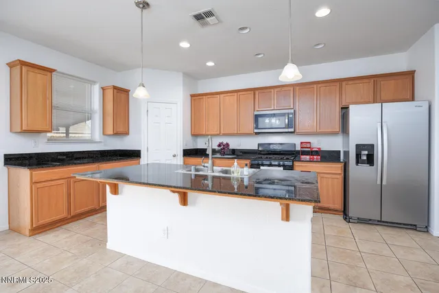 a kitchen with stainless steel appliances granite countertop a sink refrigerator and microwave