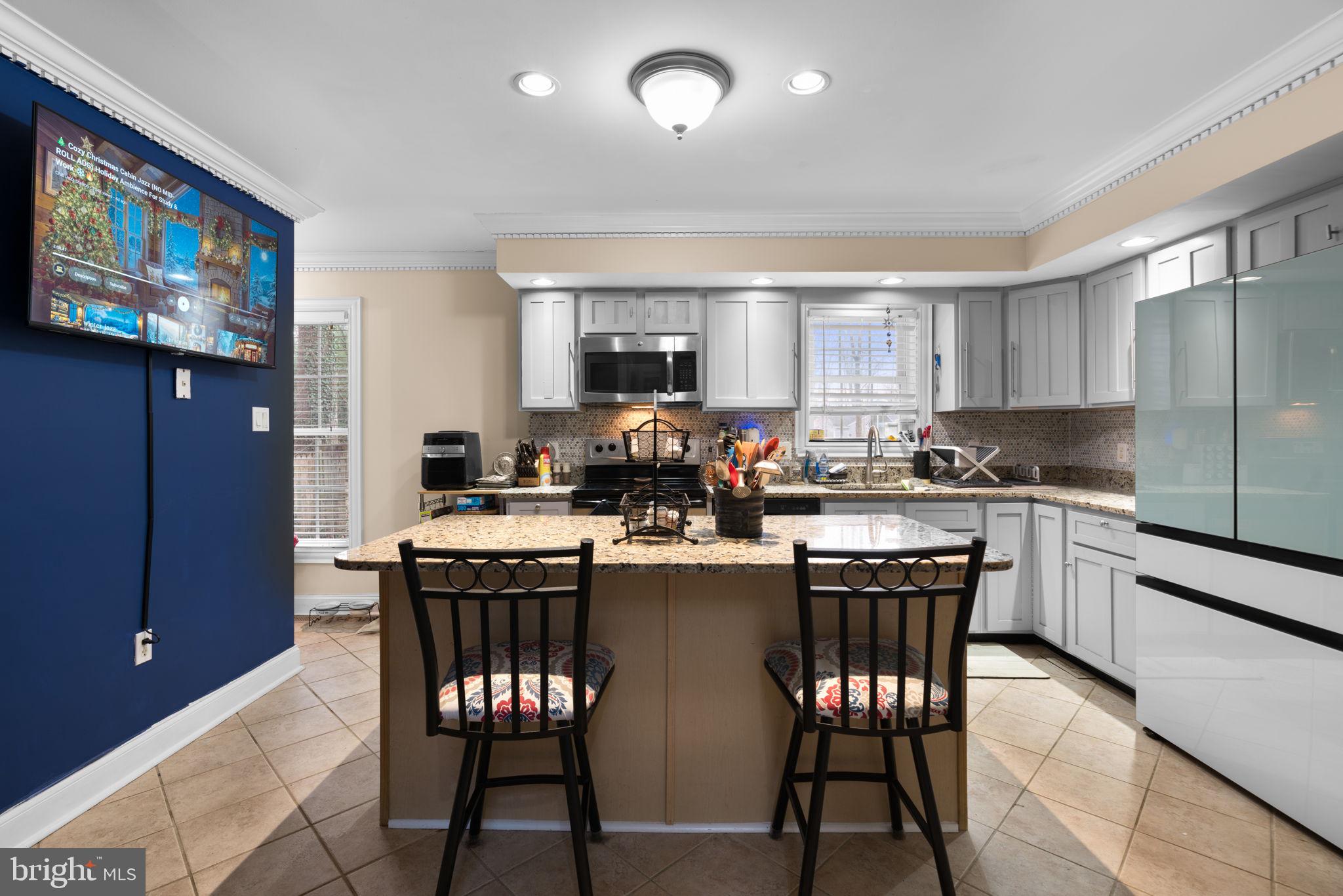 791 Central Avenue East Edgewater, MD 21037 - Photo 14 of 54 a kitchen with stainless steel appliances granite countertop a stove a refrigerator a kitchen island a dining table and chairs