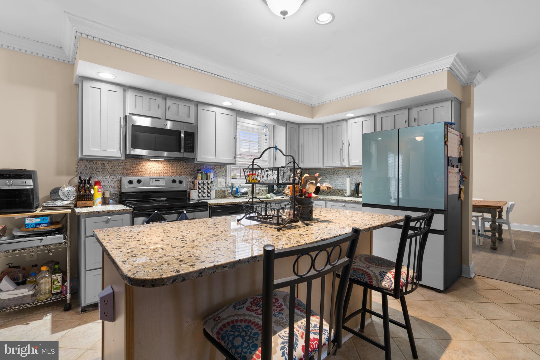 791 Central Avenue East Edgewater, MD 21037 - Photo 15 of 54 a kitchen with granite countertop kitchen island cabinets and refrigerator