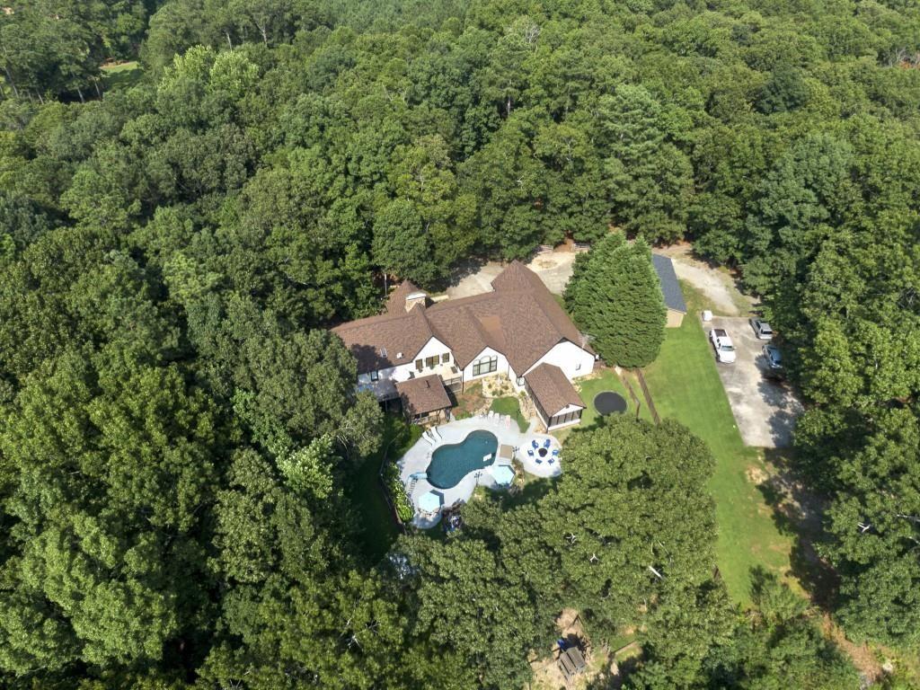 an aerial view of a house with a yard and trees