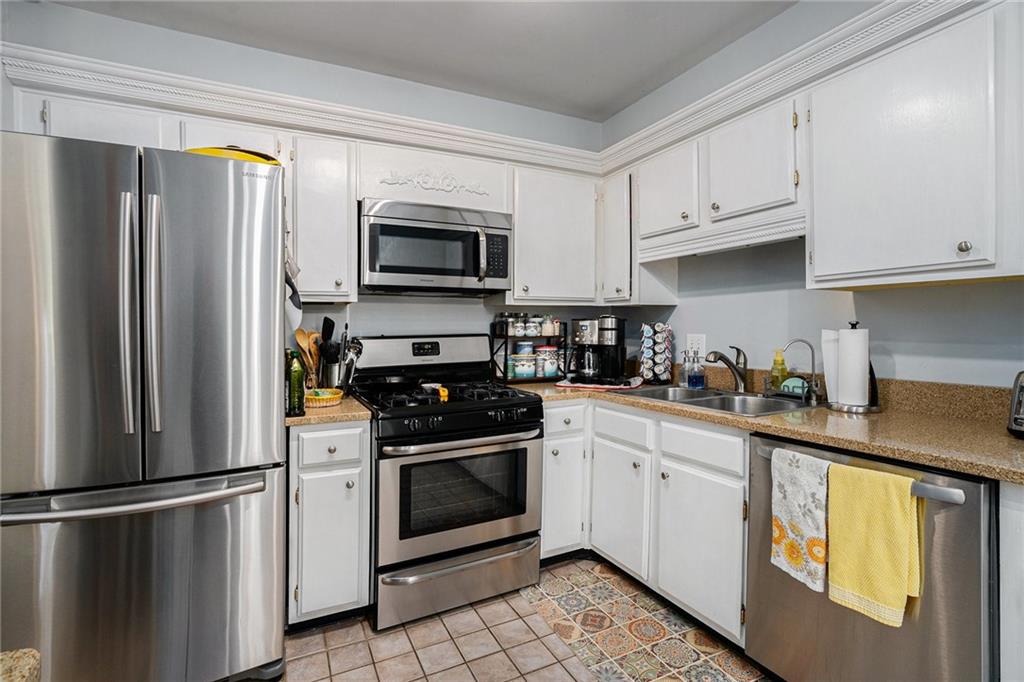 3813 Paces Ferry West Atlanta, GA 30339 - Photo 3 of 22 a kitchen with stainless steel appliances granite countertop a refrigerator stove a sink and dishwasher with wooden floor