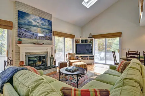 a living room with furniture fireplace and a large window