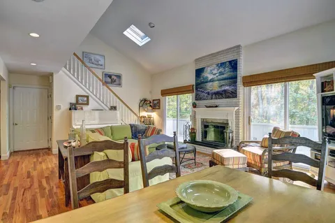 a living room with furniture a fireplace and a floor to ceiling window