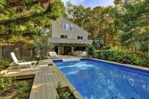 a view of a house with pool and sitting area