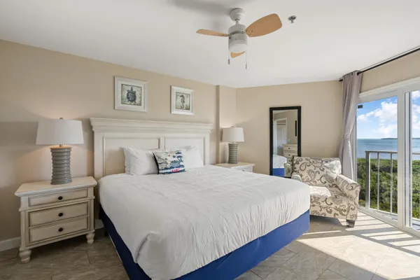 a bedroom with a bed and large windows