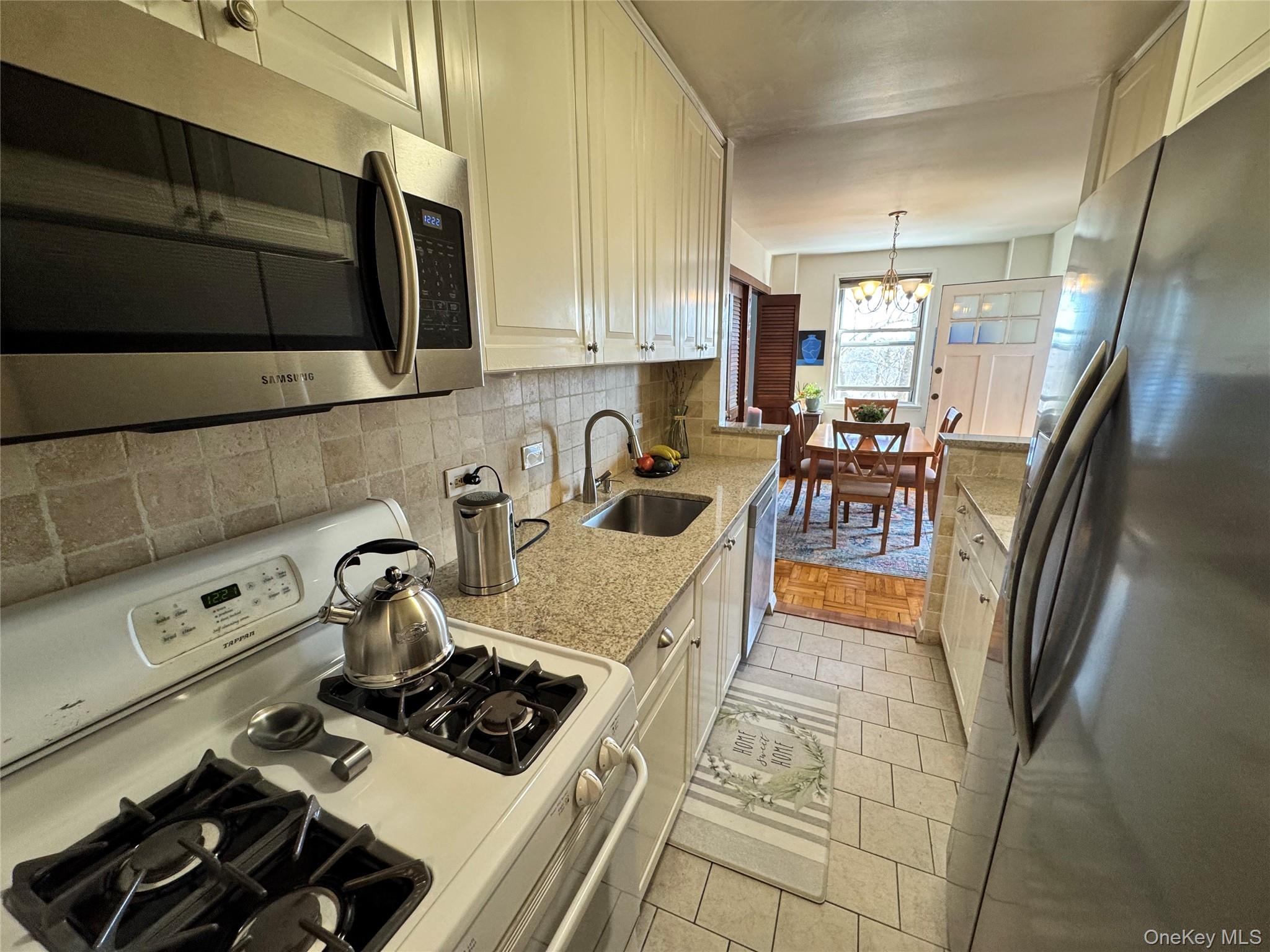 a kitchen with stainless steel appliances granite countertop a sink stove and cabinets