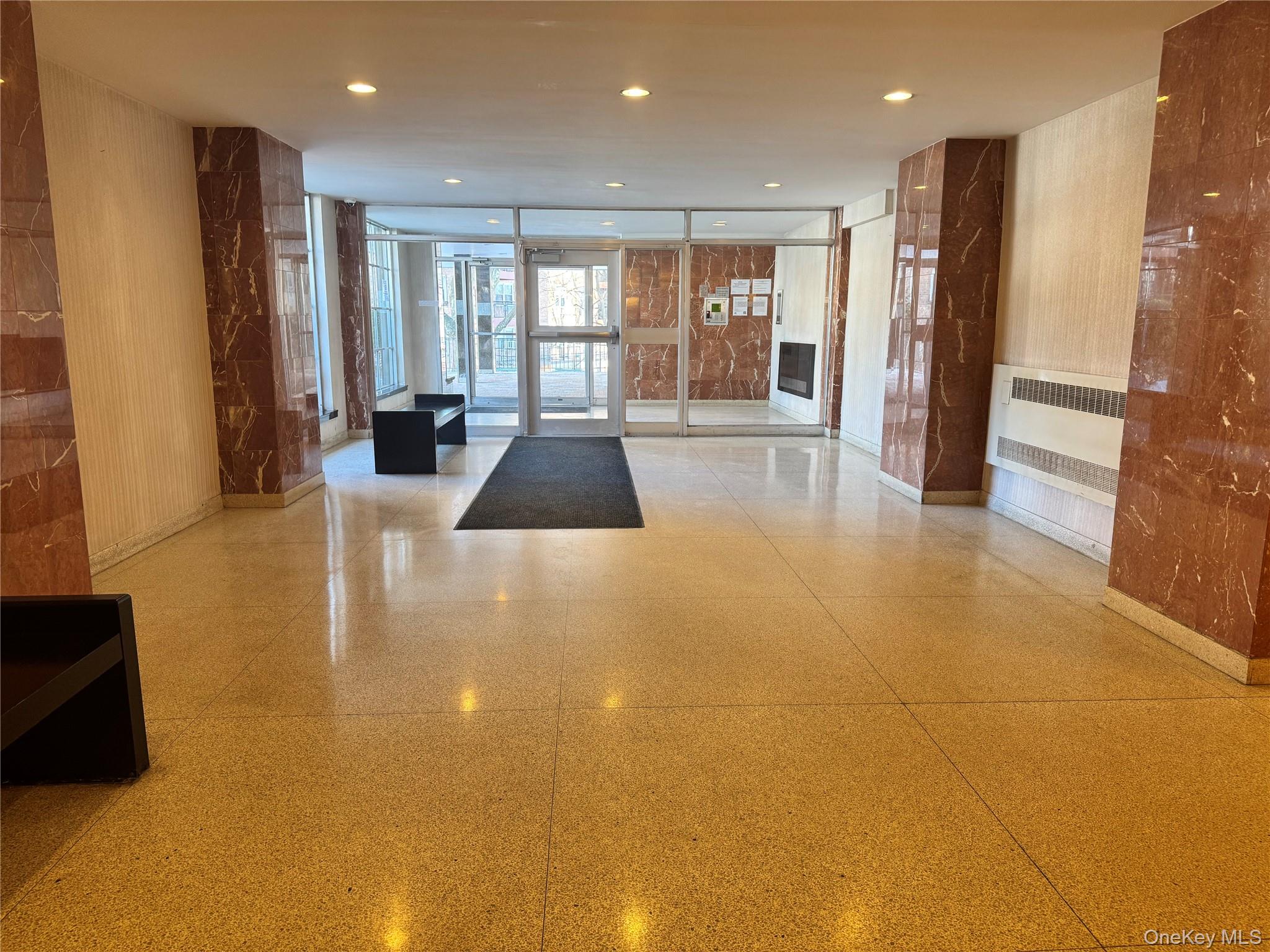 5500 Fieldston Road, Unit 3DD Bronx, NY 10471 - Photo 23 of 24 a large living room with stainless steel appliances a couch a rug a fireplace and a large window