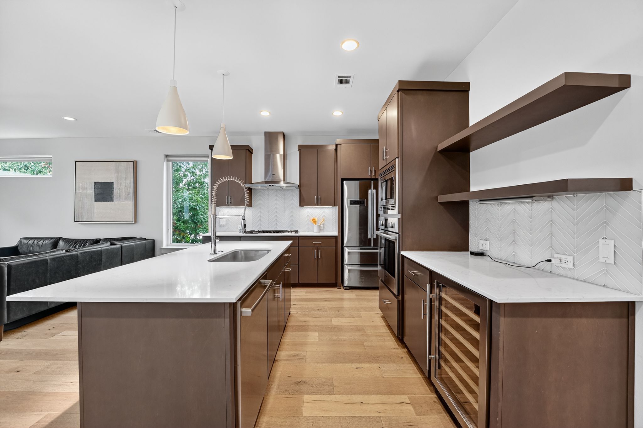2301 Bluebonnet Lane, Unit 5 Austin, TX 78704 - Photo 26 of 26 Kitchen with hanging light fixtures, beverage cooler, open floor plan, light stone counters, and backsplash